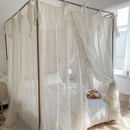 Close-up of the natural linen-colored ruffled bed drapes, with a subtle texture and delicate ties on the top, blending with a modern bedroom style.