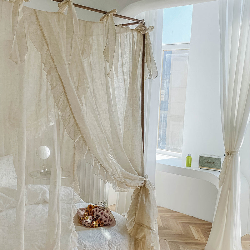 A side view of the natural linen ruffled drapes, showing how the curtains tie back to create an elegant and open look, with a sunlit window in the background.