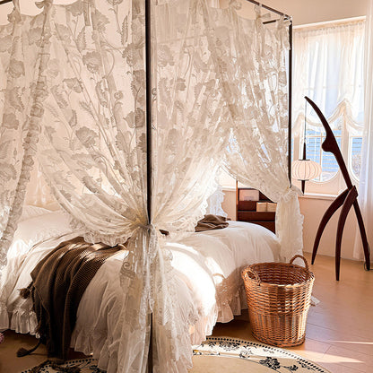 Bedroom with a canopy bed draped in lace curtains, a wooden chair, and a basket.