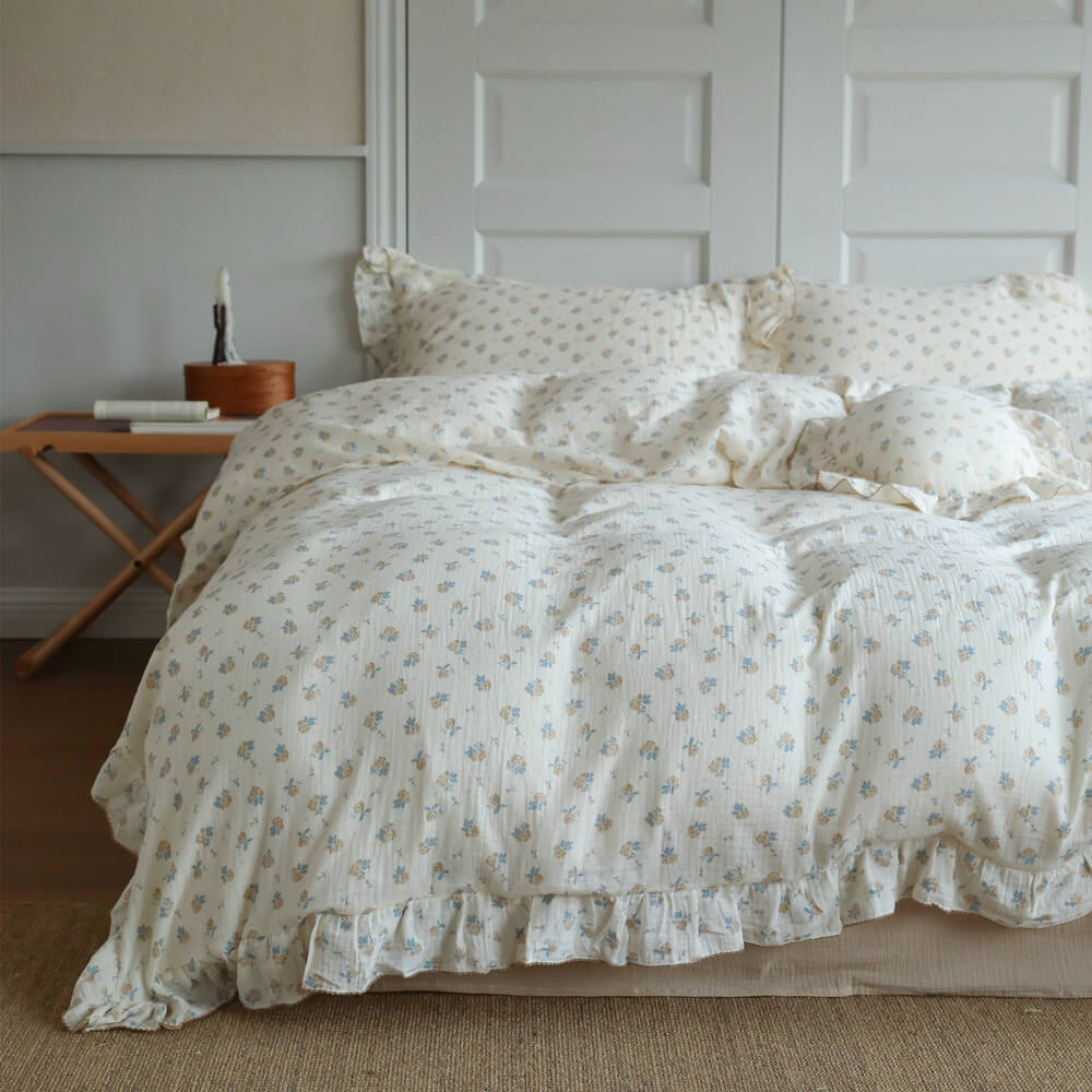 Blue rosebud duvet cover set styled on a full bed with soft ruffled edges and matching pillowcases