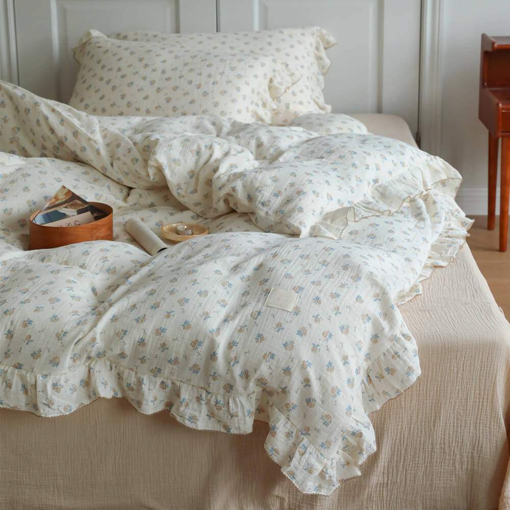 Blue rosebud duvet cover set shown from the front with ruffled edges and matching floral pillows
