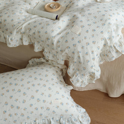 Close view of blue rosebud duvet cover and pillowcase with ruffled cotton muslin details