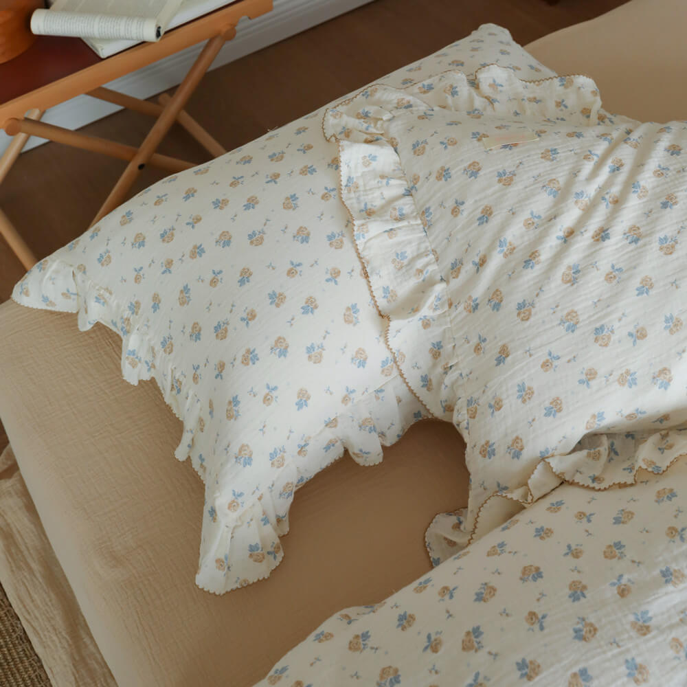 Blue rosebud pillowcase and duvet cover detail showing soft cottage floral bedding layers