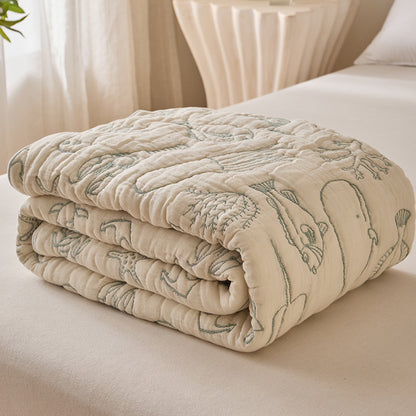 Folded sea life cotton blanket in muted green and ivory jacquard design
