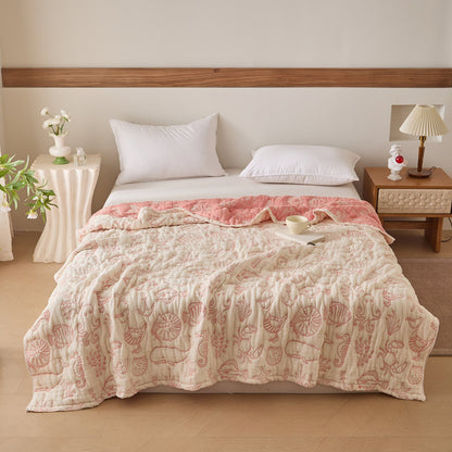Reversible sea life cotton blanket in sea-green and ivory tones styled on a full bed