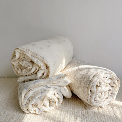 Three animal print comforters in lamb, kitty, and woodland patterns, crafted from breathable cotton muslin with lace trim, layered together