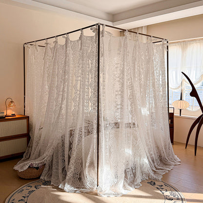 Lace canopy bed in a bedroom setting with a lamp and rug.