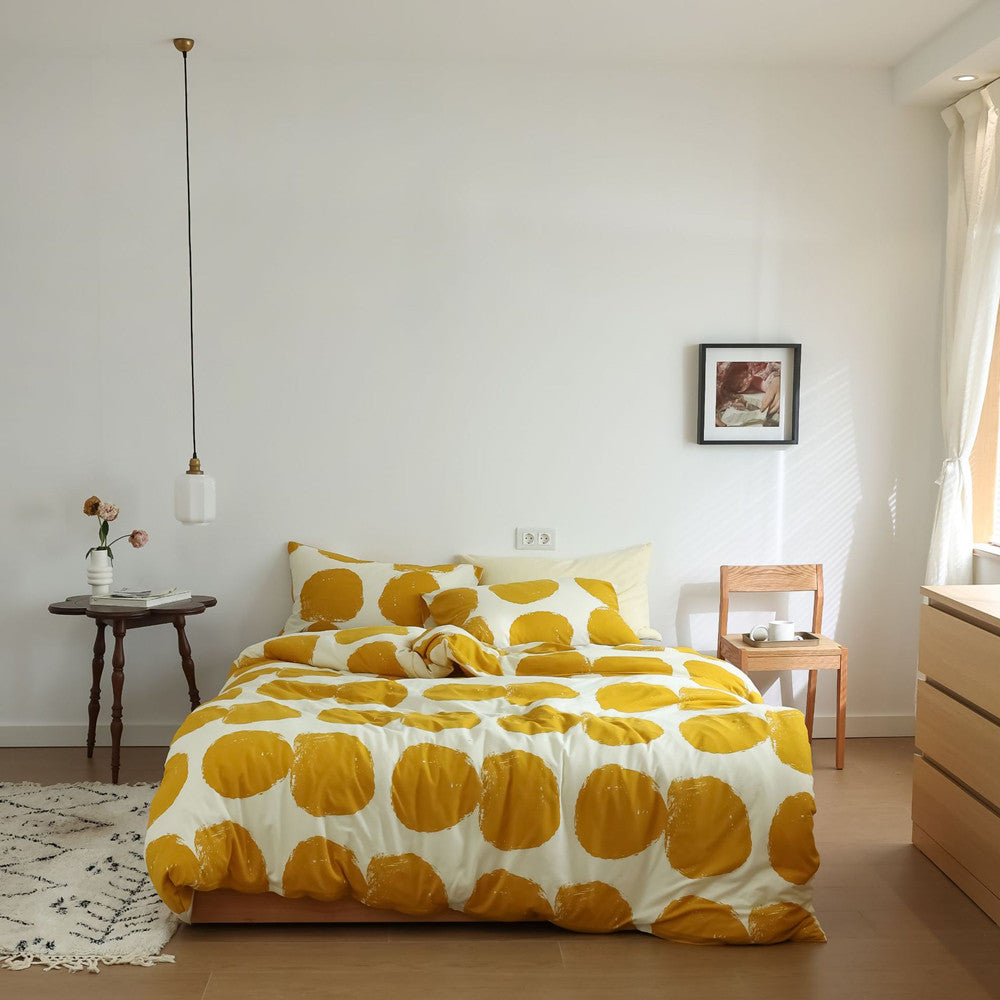 Full bed view of yellow large dot duvet cover set with gray sheet and matching pillowcases in modern bedroom