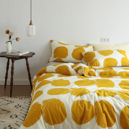 Side angle showing yellow large dot duvet cover set with gray flat sheet and pillowcases