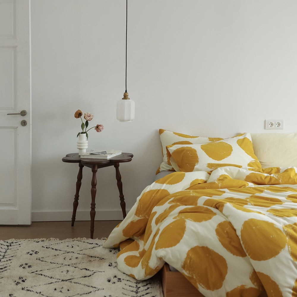 Styled bedroom scene with yellow large dot duvet cover set highlighting bold pattern and soft cotton jersey