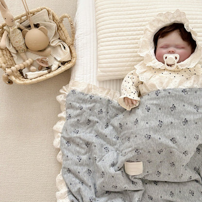 Sleeping baby covered with grey bear print jersey comforter
