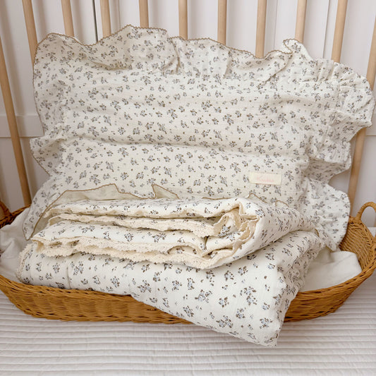 Blue bud kids comforter with ruffled pillow in crib