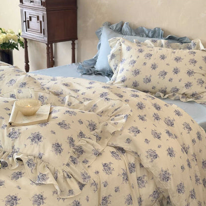 A beautifully styled bed with the Dusty Blue Floral duvet cover, featuring charming ruffle trim and a vintage-inspired floral print