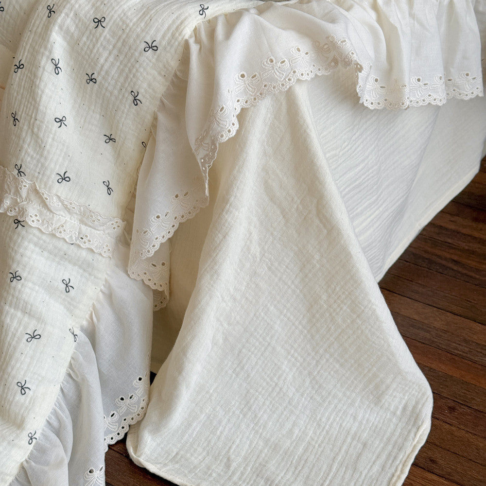 Scalloped lace and double-layered ruffles on cream cotton comforter