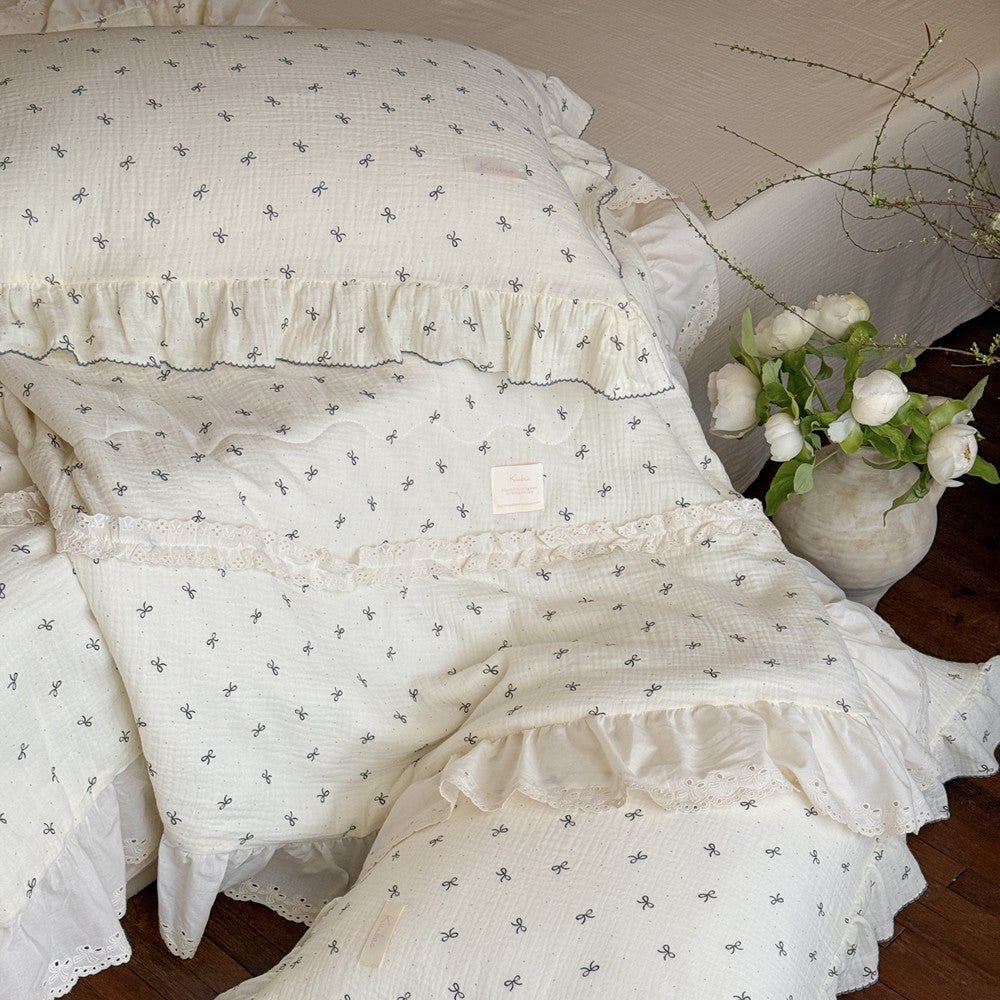Detailed view of corner edge with bow print and lace on cotton comforter