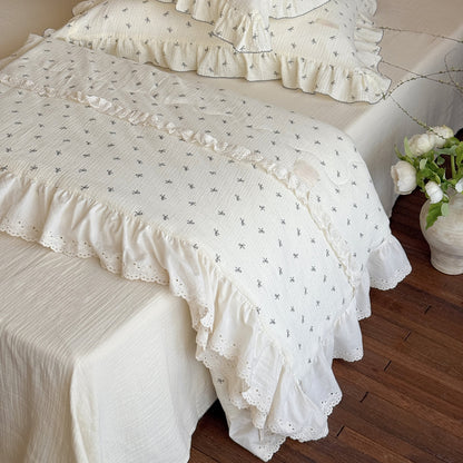 Side fold showing gauze texture and lace trim of lightweight comforter