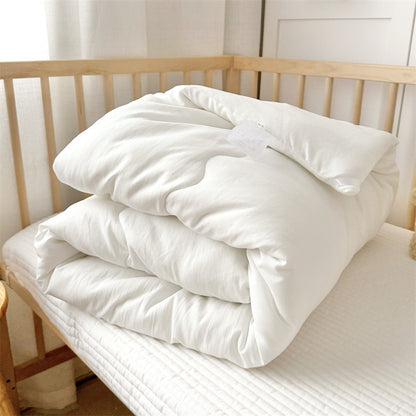 Toddler comforter insert and matching pillow displayed on wooden bed frame, ready for duvet cover pairing