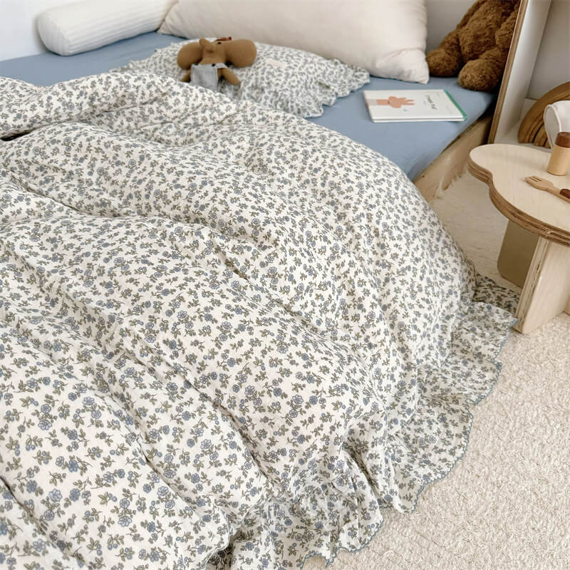Close-up of ruffled duvet cover in blue floral cotton gauze fabric