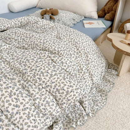 Close-up of ruffled duvet cover in blue floral cotton gauze fabric