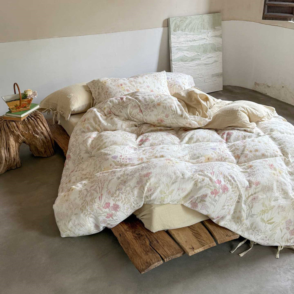 Full view of blush white floral cotton bedding set on wooden bed