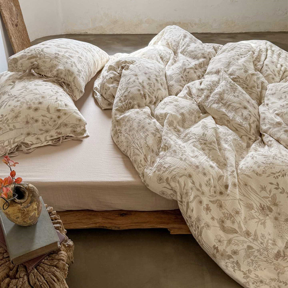 Side view of reversible floral cotton gauze bedding set on wooden bed