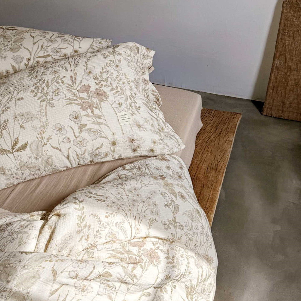 Side view of reversible floral cotton gauze bedding set on wooden bed