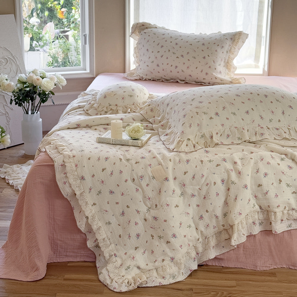 Delicate floral comforter with soft ruffles styled on pink bedding