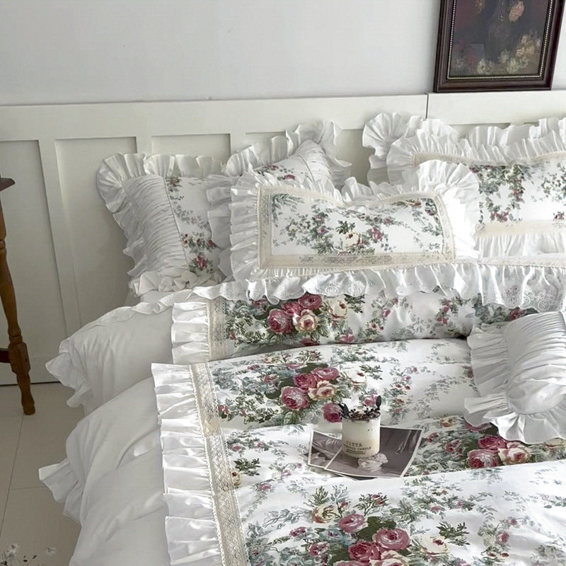 Full bed view of white floral cotton bedding with ruffle