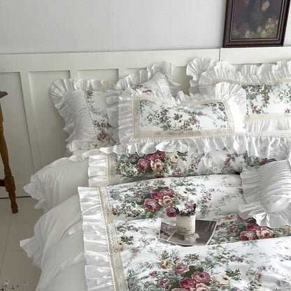 Full bed view of white floral cotton bedding with ruffle