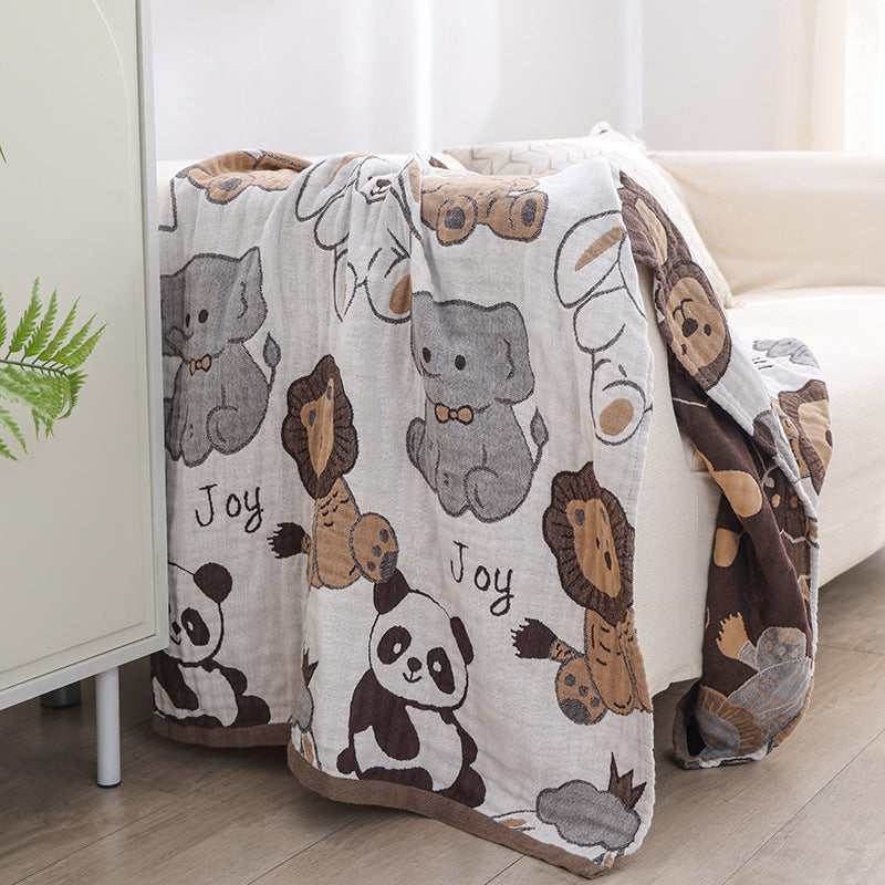 Reversible cotton gauze animal blanket draped over a sofa