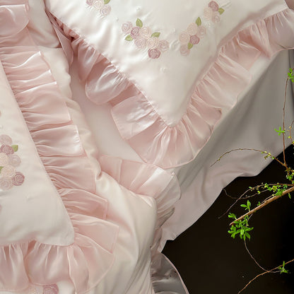 Cluster of pink ruffled pillows with embroidery