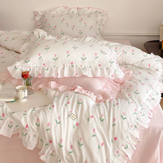 A bed with a pink tulip print cotton bedding set, featuring ruffle trim