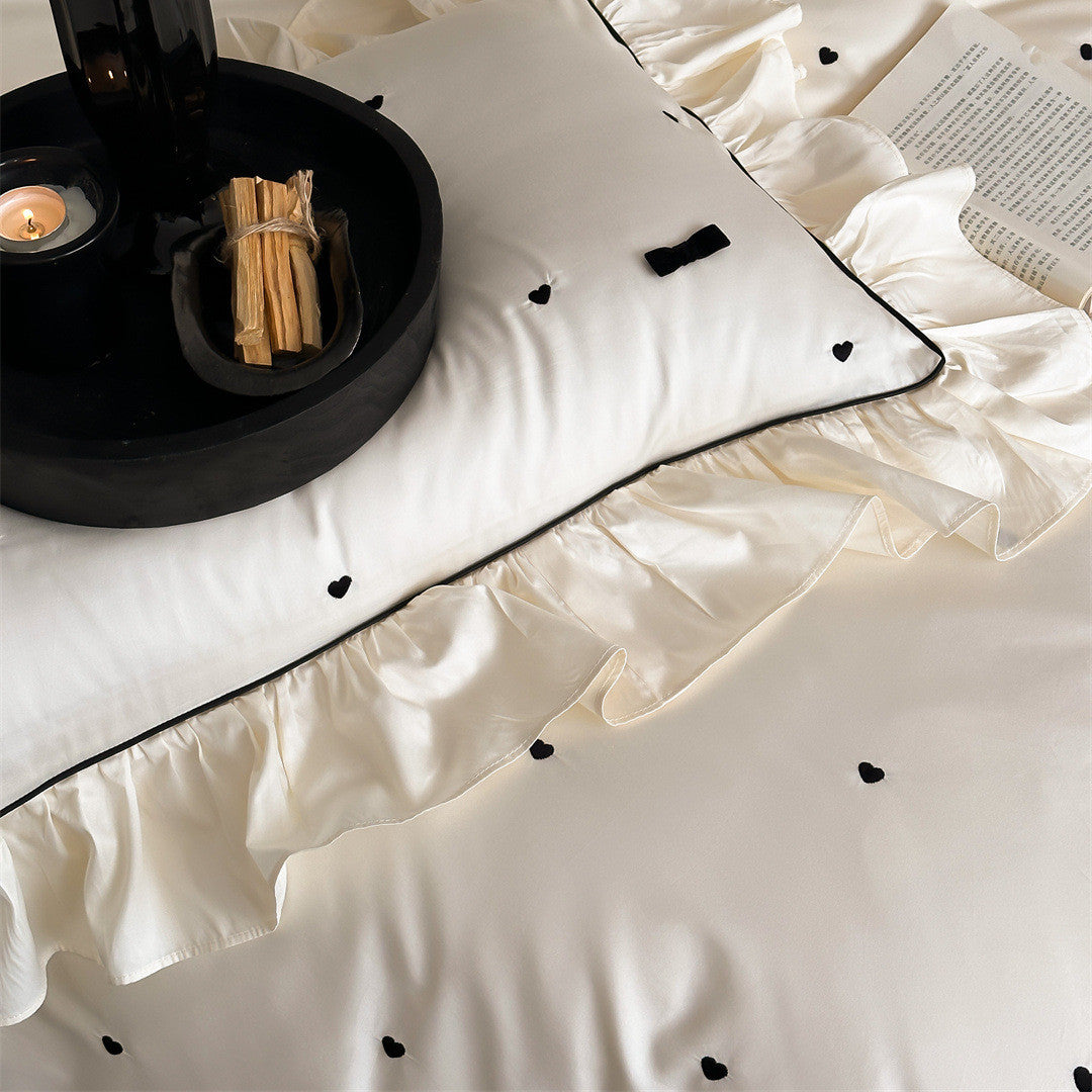 Close-up of heart embroidery and soft cotton fabric in ivory set