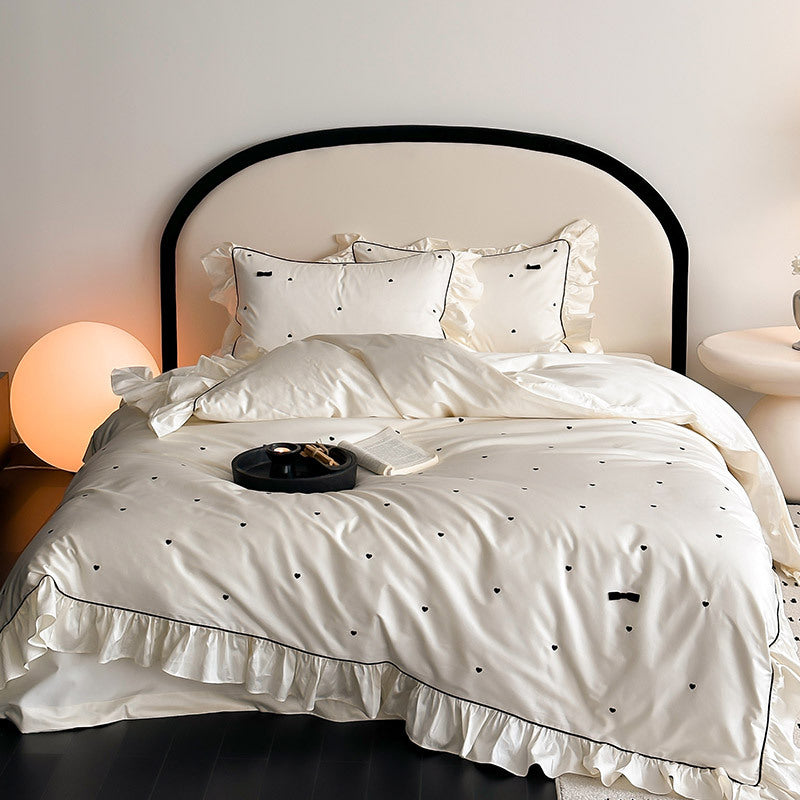 Ivory ruffled bedding set with heart embroidery and black trim