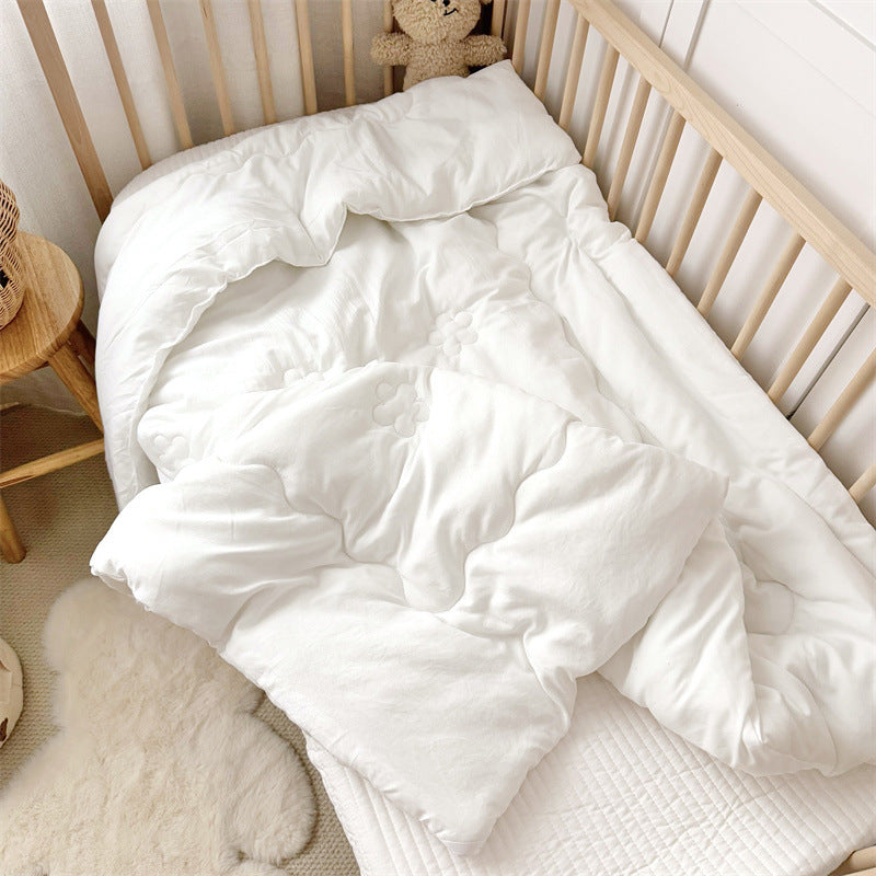Close-up of folded toddler comforter insert showing quilted texture and smooth fabric surface