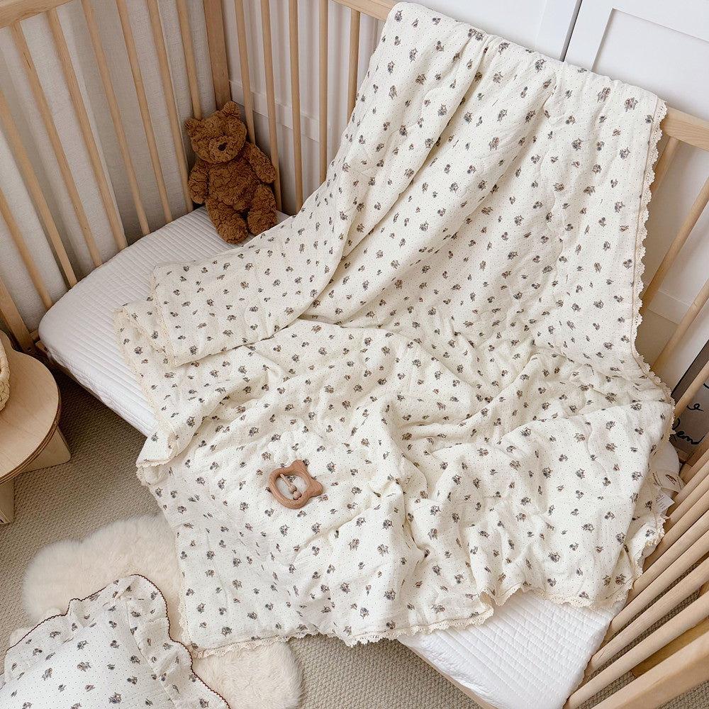 Floral comforter draped across crib side