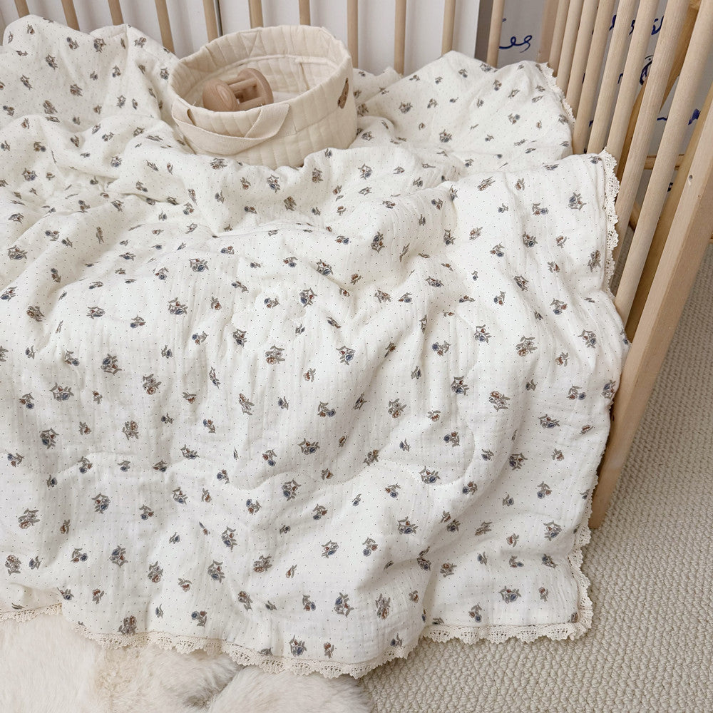 Dotted floral comforter in crib with storage basket